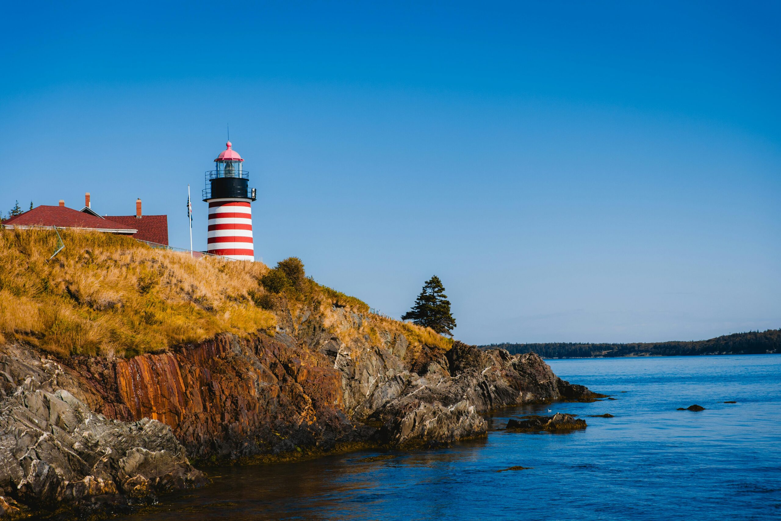 The rocky Maine coastline near Kennebunkport on a clear spring morning, with calm water and soft light