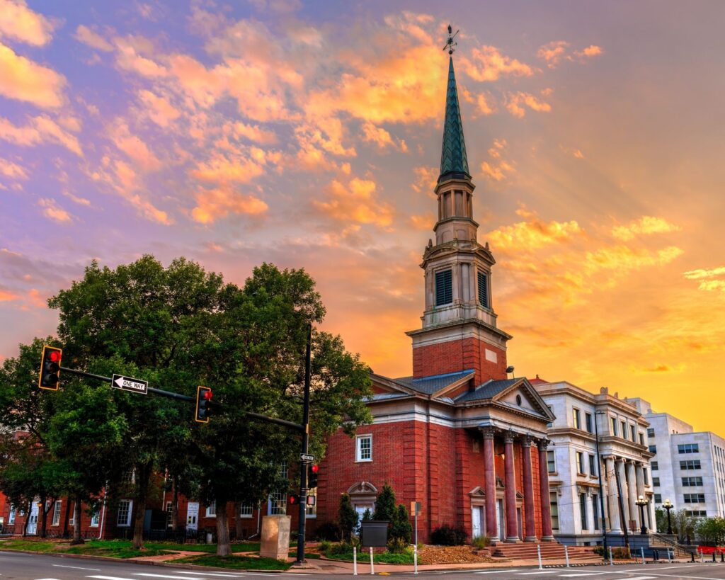 Sunset light shines on a historic church and landscape of downtown Natchez.
